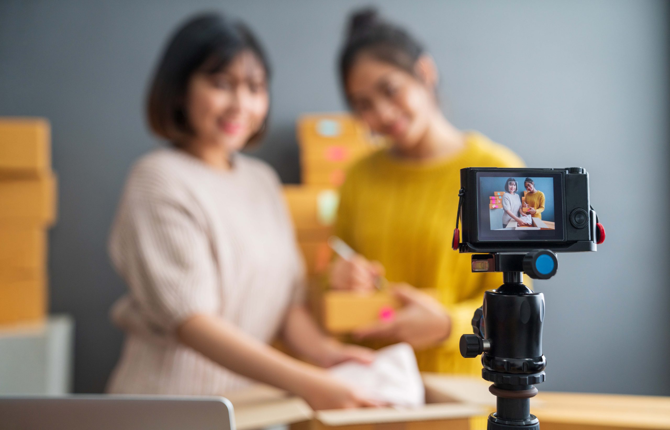 Blurry Photo of Two Women Reviewing a Product on Camera