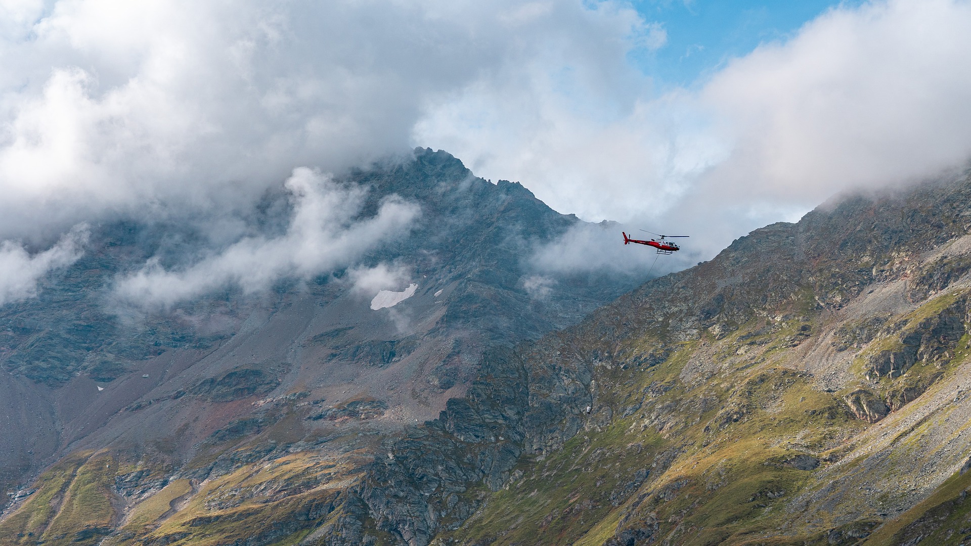 Red Helicopter Flying Over Mountains